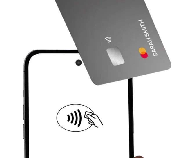Hand hält ein Smartphone, an das eine Bankkarte gehalten wird